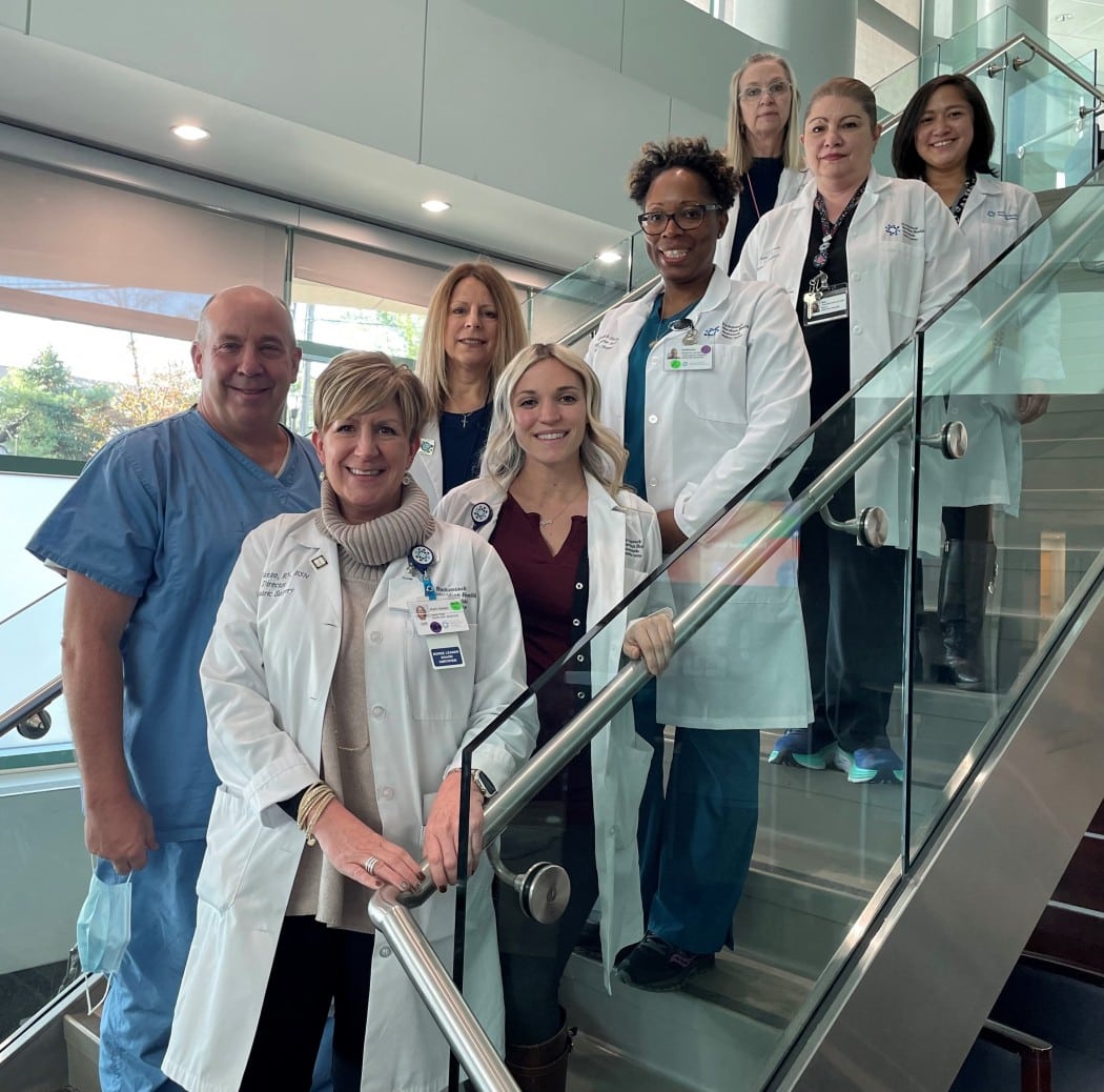 Group of doctors in lab coats standing on stairs